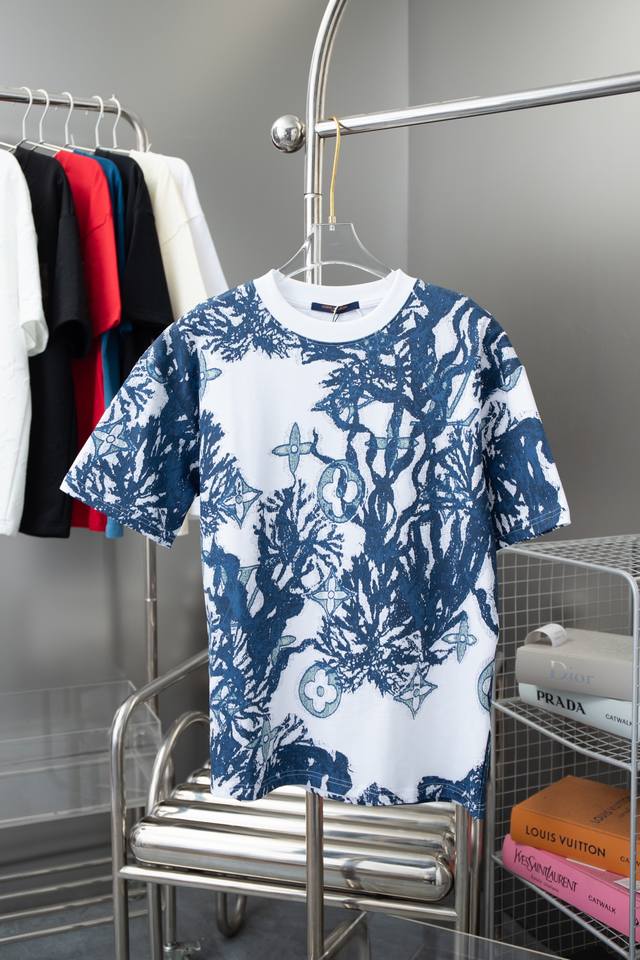 Lv Ss春夏新款短袖 这款清新的棉质 T 恤采用精致的提花针织图案 引人注目 它采用该系列的 Monogram Aquagarden 珊瑚和海藻展示 其水蓝色